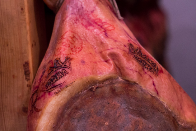 PROSCIUTTO这个上的这个标志是确保猪肉的养殖、屠宰和腌制都是在规章标准范围内完成的，最终会打上五星Parma公爵皇冠，作为通过最终检查的标志