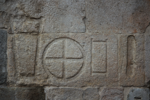 雕刻在PIAZZA ERBE墙上的过去的测量标志（不同的形状代表纺织品、餐饭、砖、谷物和种子）